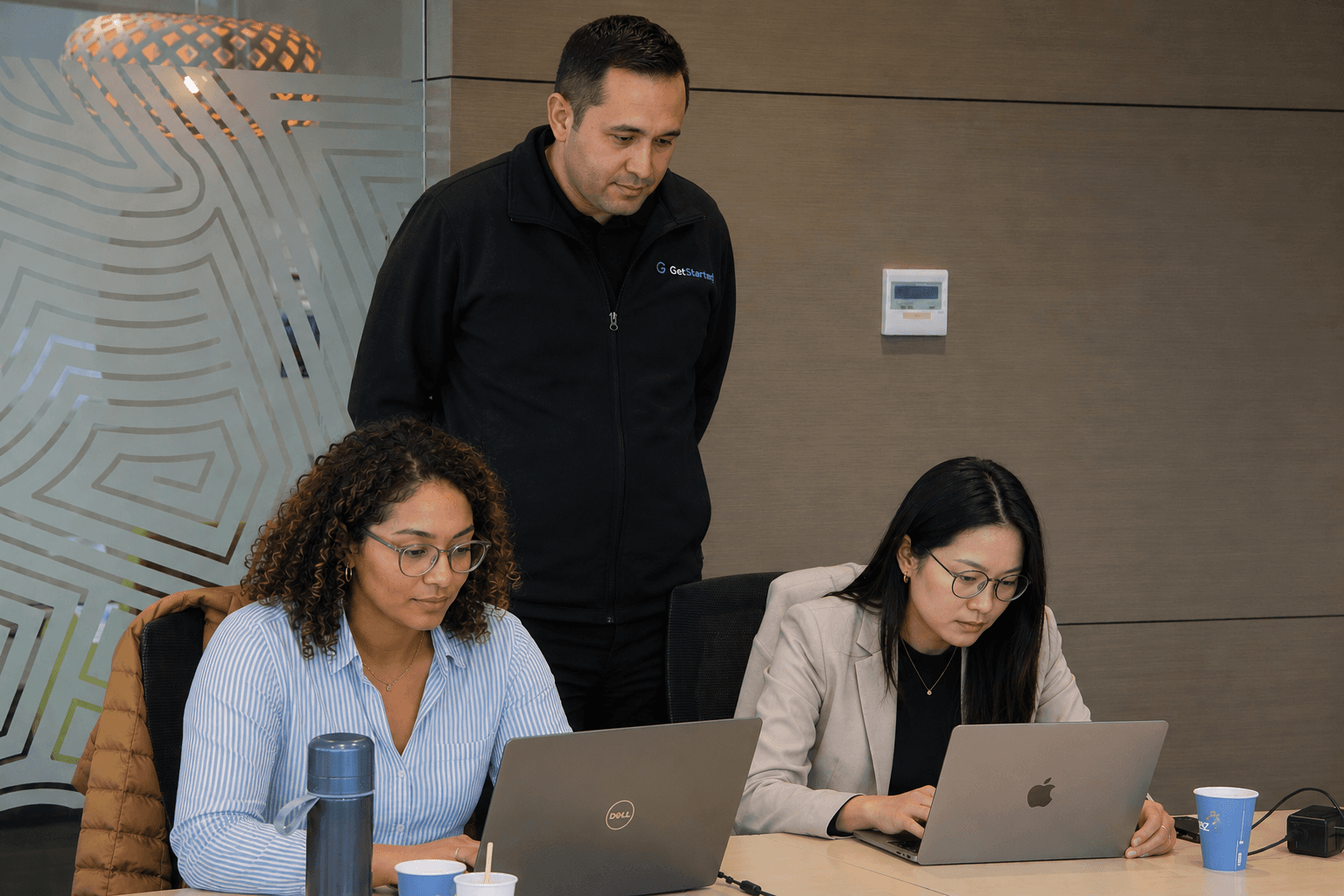 A GetStarted trainer helping business owners use AI tools on their laptops during a hands-on session