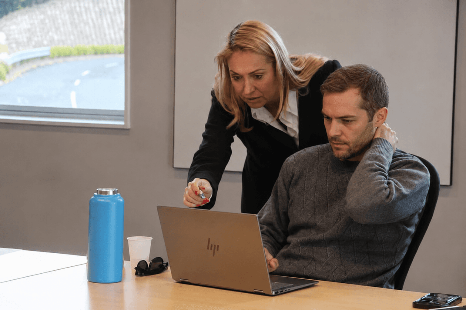 A GetStarted trainer giving one-on-one AI coaching, pointing at a laptop screen
